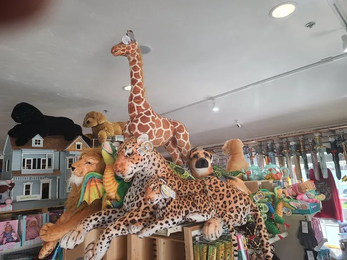 Giraffe, lion and leopard plush animals with a dollhouse