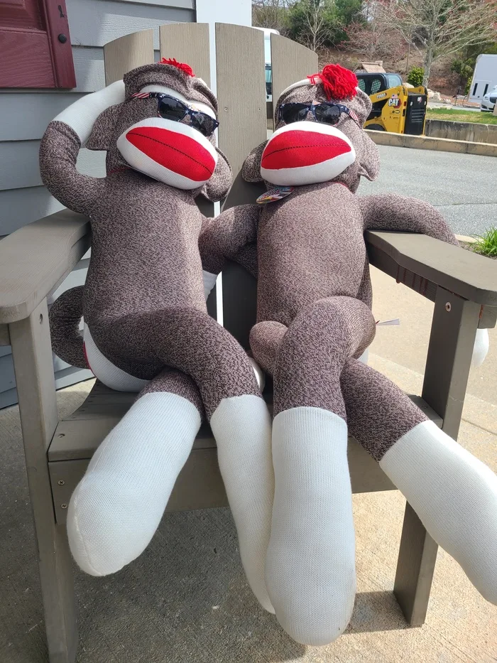 Sock monkey plush toys sitting outside the store